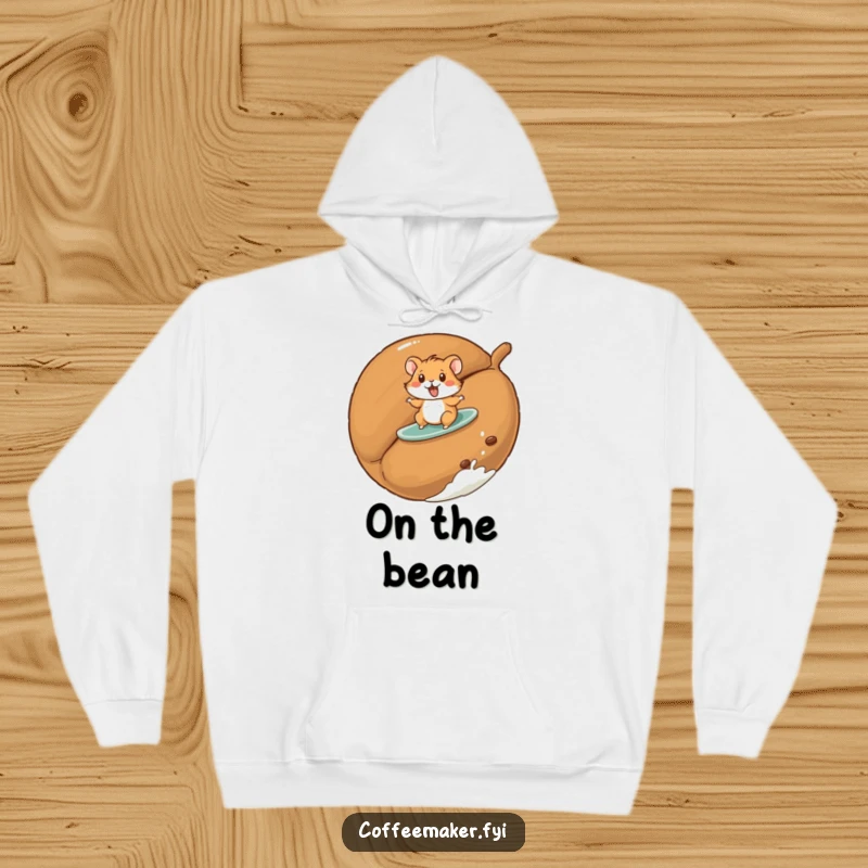 Funny hamster hoodie with a playful hamster surfing on a giant roasted coffee bean, perfect for cozy fun.